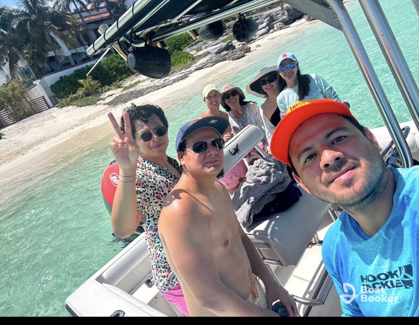 A cheerful group poses for a selfie on a boat, enjoying a sunny day at the beach — perfect for memorable outings and celebrations on the water.