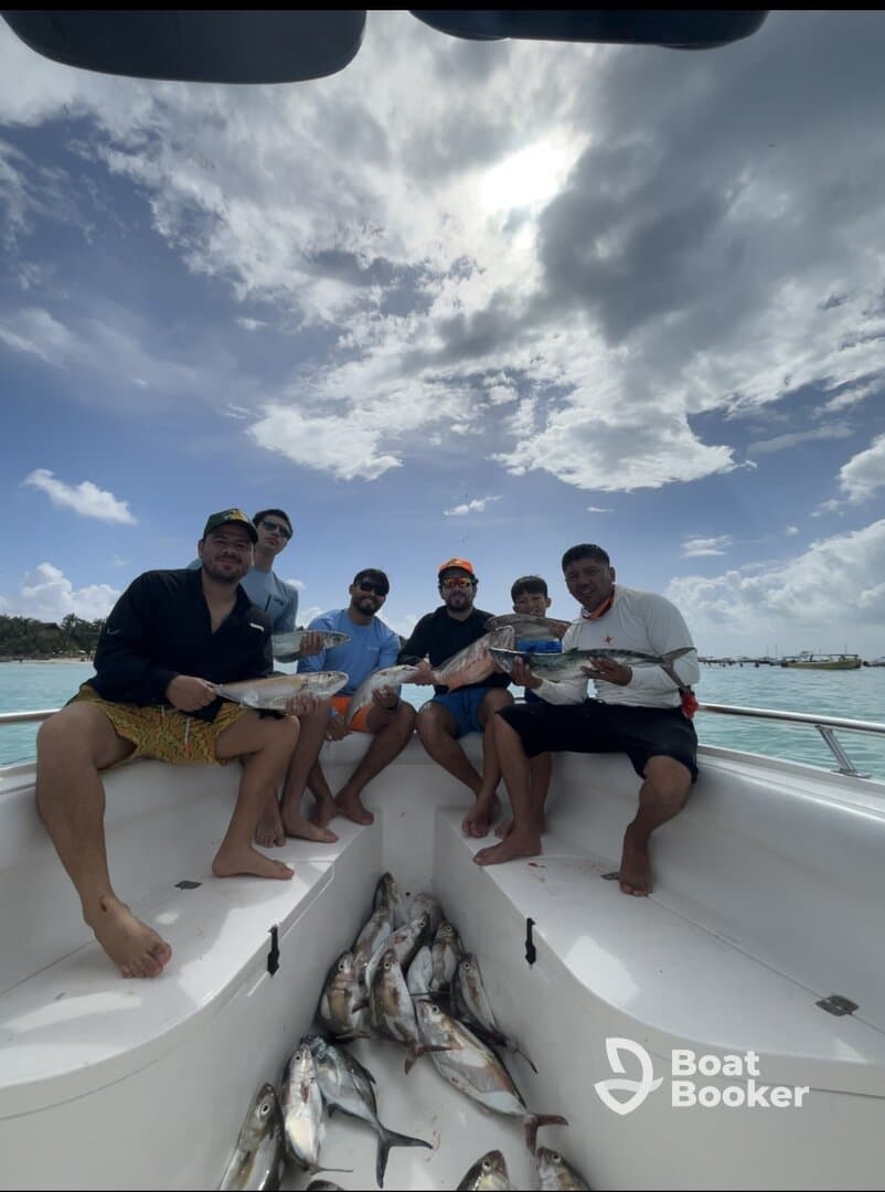 A group of friends proudly displays their catch after a successful fishing trip, showcasing the joy of fishing adventures on the water.
