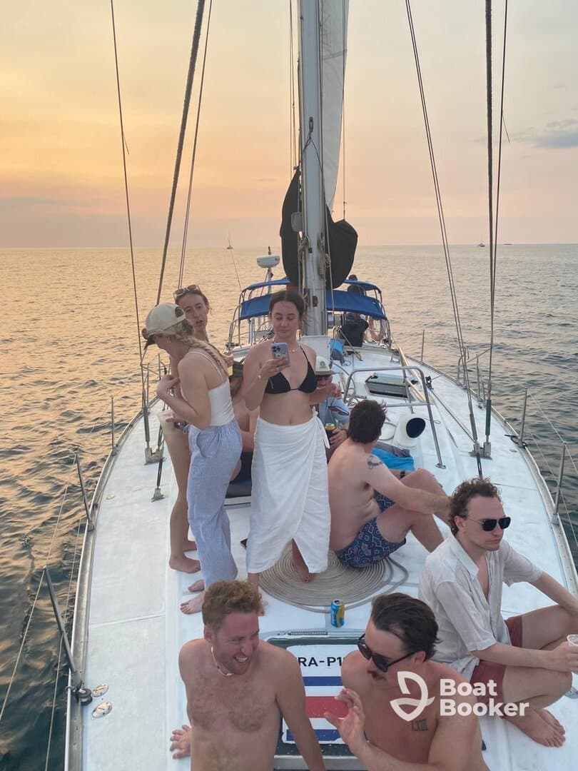 A lively group enjoys a sunset sailing experience aboard a yacht, capturing the essence of fun and camaraderie on the water.