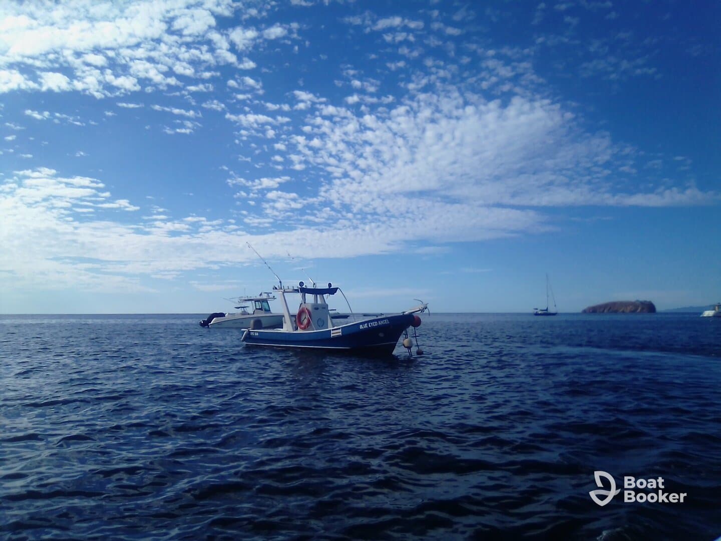 A scenic view of a fishing boat navigating through calm waters under a clear blue sky, showcasing the tranquility of a day on the sea.
