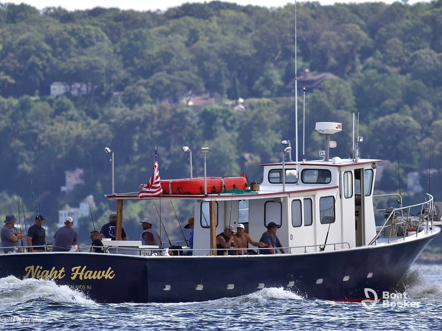 A group of anglers aboard the 'Night Hawk' boat enjoy a day of fishing on the water, showcasing camaraderie and adventure.
