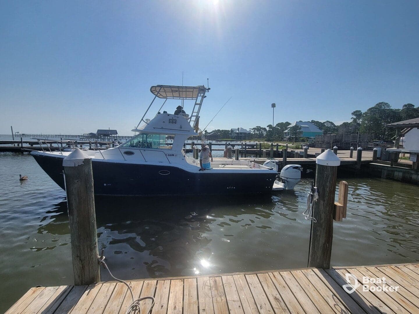 A fishing boat is docked at the marina, showcasing its sleek design against a clear blue sky — perfect for a day on the water.