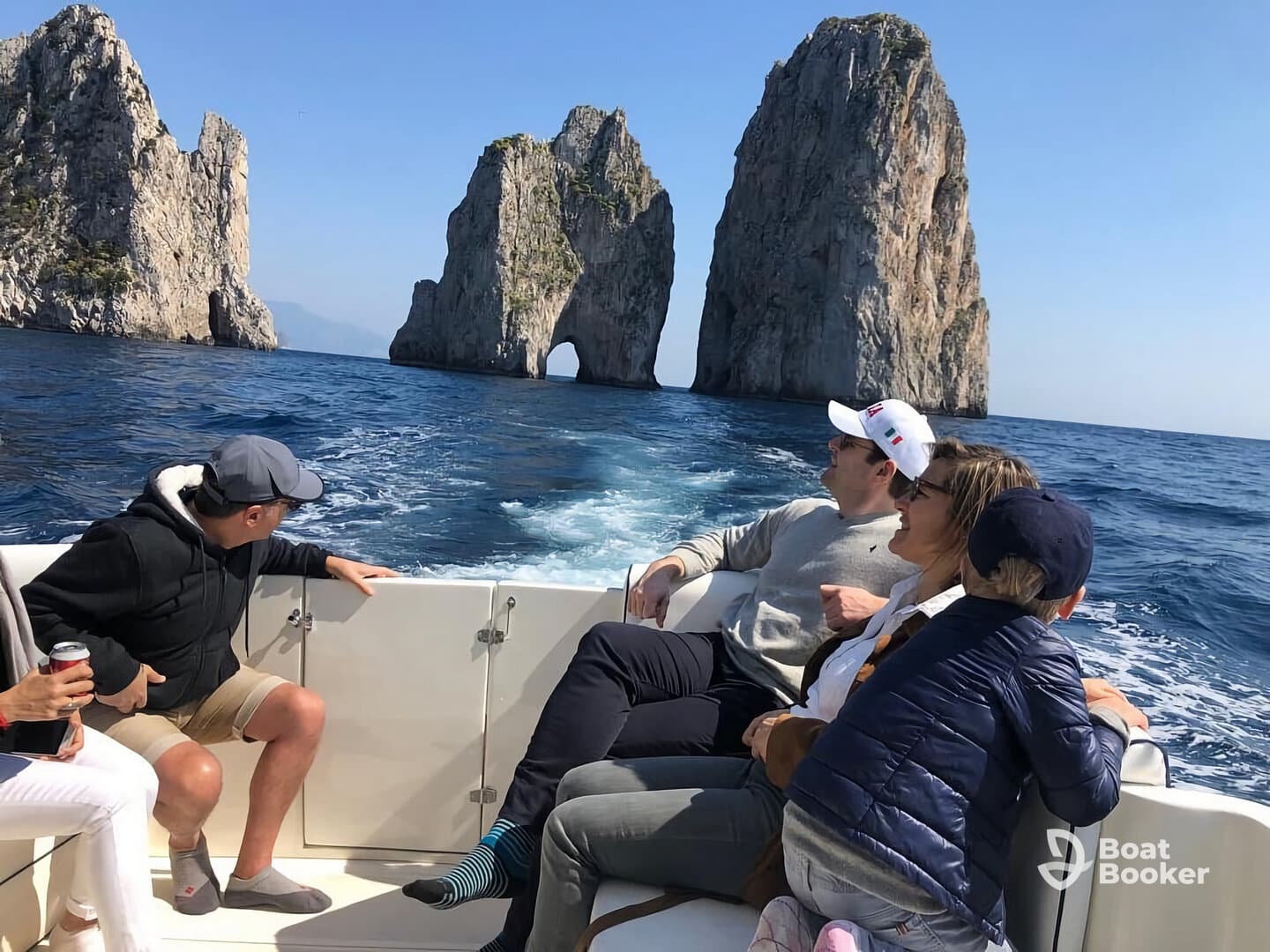 A joyful group enjoys a scenic boat ride near the iconic rock formations of Capri, capturing a memorable family experience on the water.