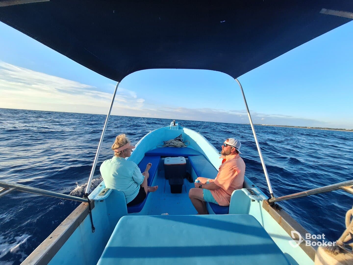 A couple enjoys a serene moment aboard a small boat, surrounded by the vast ocean — perfect for a relaxing day on the water.