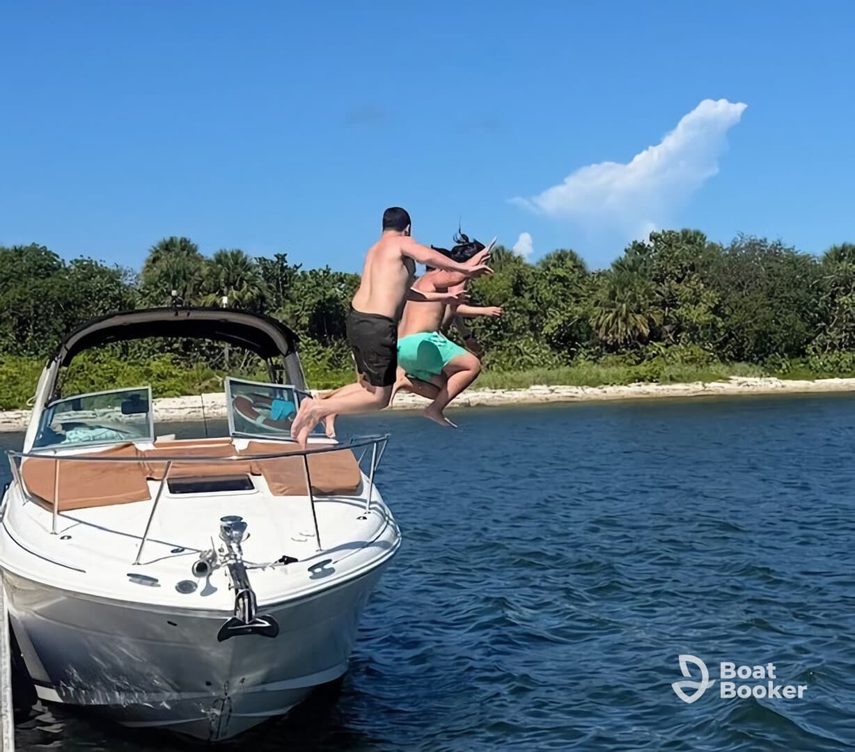 Two friends leap off the bow of a boat into the water, capturing the excitement of summer fun and adventure on the water.