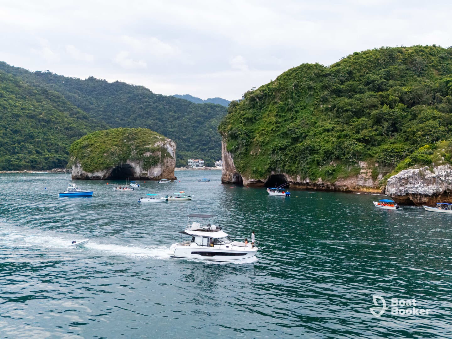 A scenic view of multiple boats navigating through a picturesque coastal area, showcasing the beauty of nature and the excitement of exploration on the water.