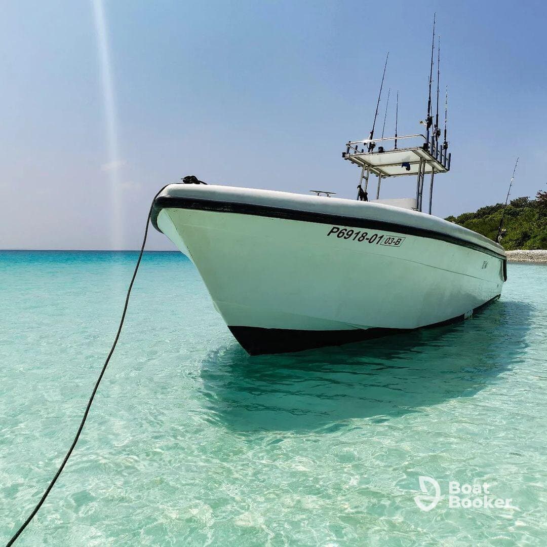 A striking view of a fishing boat docked in crystal-clear waters, showcasing its sleek design against a serene backdrop — perfect for fishing trips or coastal adventures.