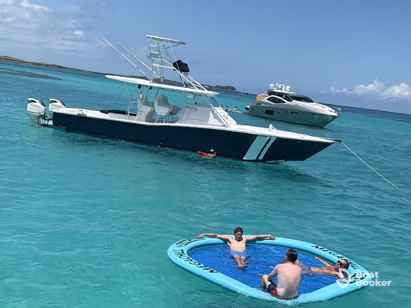 A group of friends enjoys a sunny day on the water, relaxing on a floating mat while a boat is anchored nearby — perfect for summer fun and aquatic adventures.
