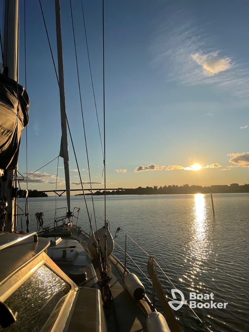 A serene sunset view from the deck of a sailboat, showcasing the tranquil waters and the beauty of nature — perfect for peaceful evening cruises.