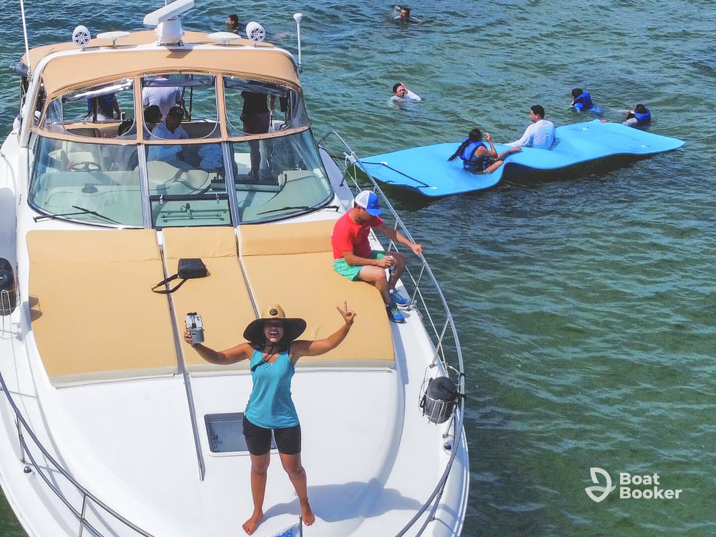 A lively group enjoys a fun day on the water, with some swimming and others relaxing on the boat — perfect for summer adventures and family outings.