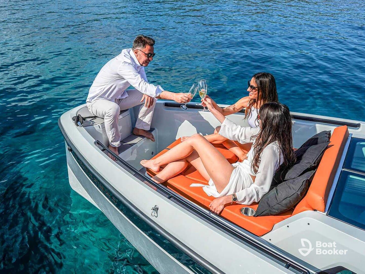 A group of friends enjoys a celebratory toast with cocktails on a sleek yacht, surrounded by crystal-clear waters — perfect for memorable moments on the water.