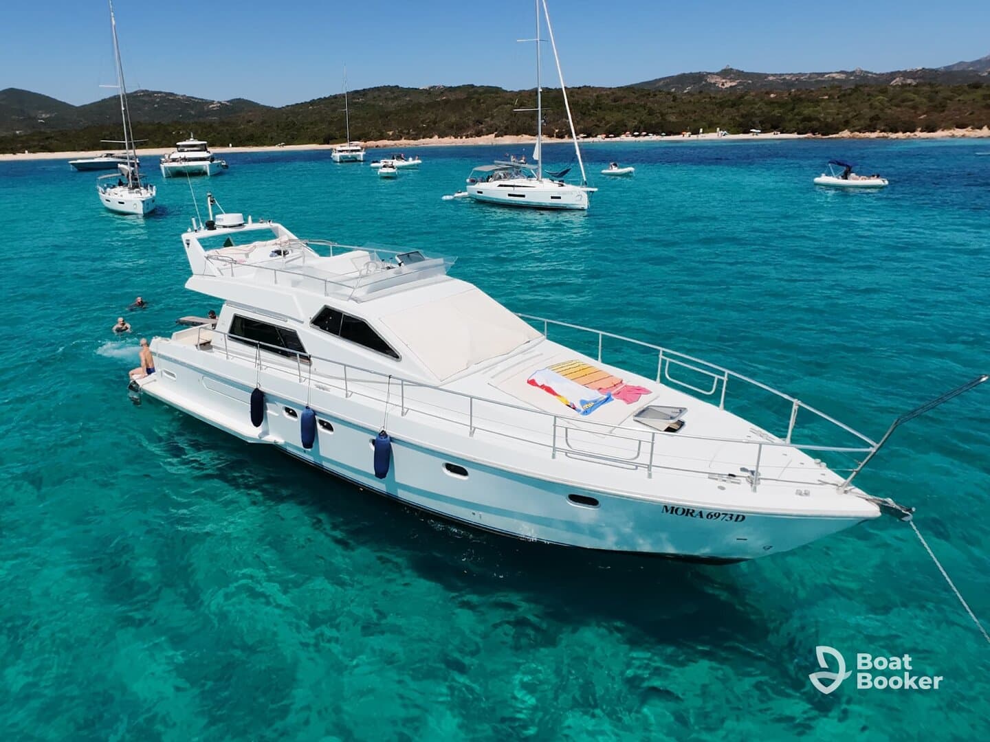 A lively scene featuring guests swimming near a yacht in stunning turquoise waters, perfect for summer adventures and beach outings.