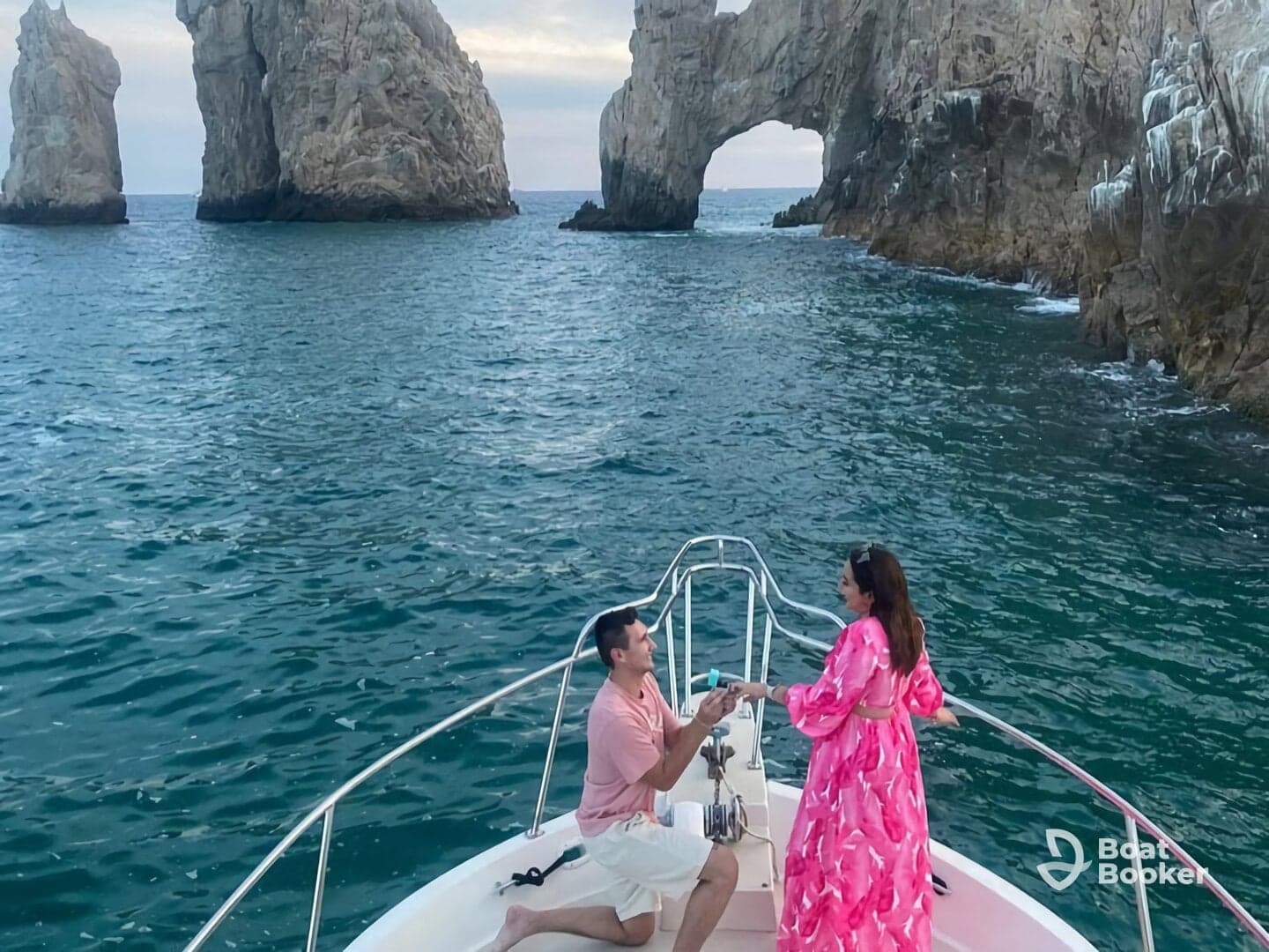 A romantic proposal takes place on a boat with stunning rock formations in the background, creating a perfect setting for unforgettable moments.