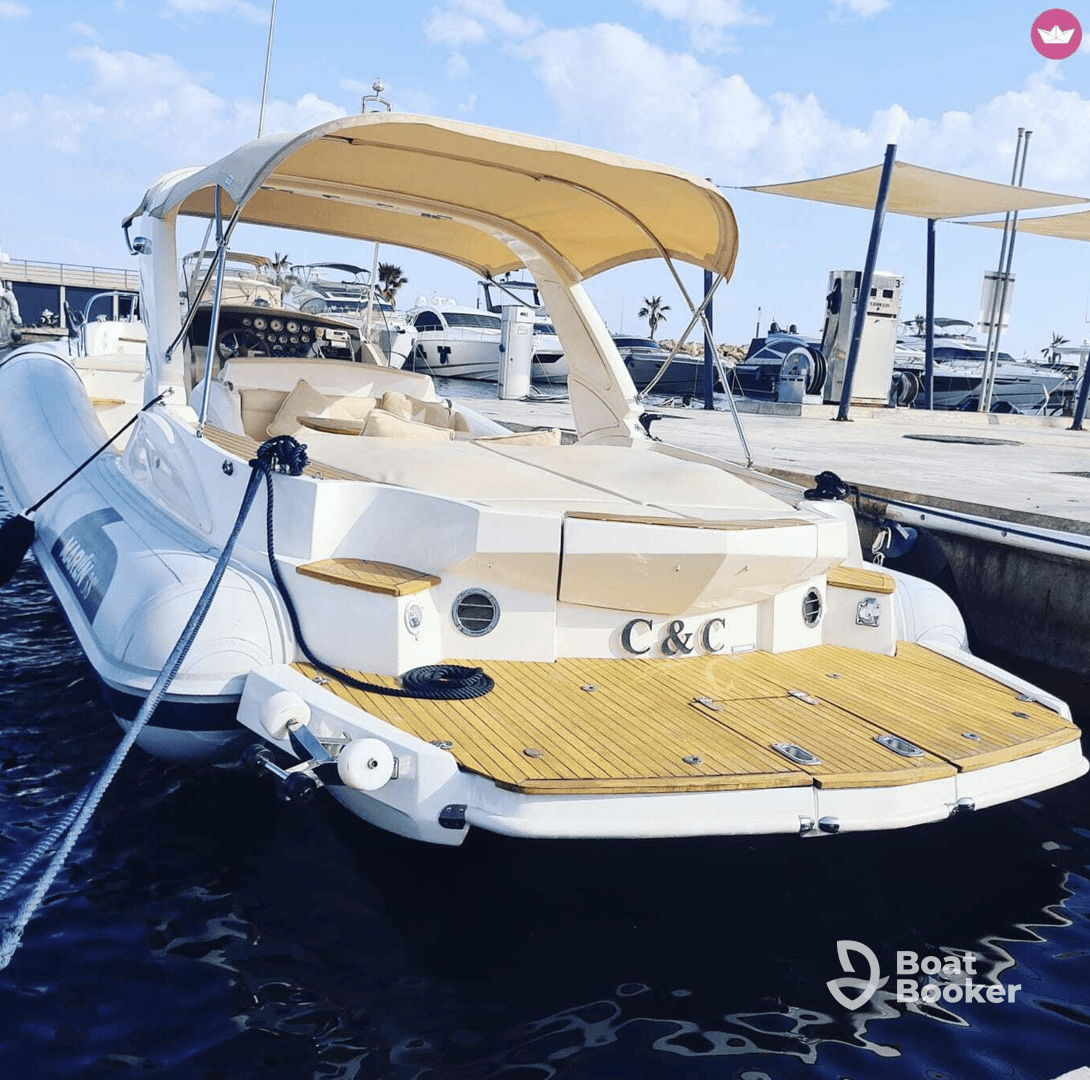 A sleek yacht docked at the marina, showcasing its elegant design and spacious rear deck, perfect for relaxing on the water.