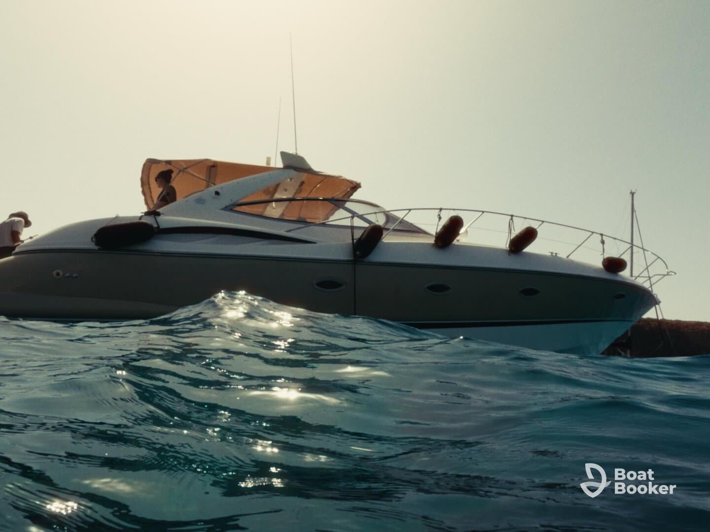 A stunning view of a boat with guests onboard, captured from the water, showcasing a perfect day on the sea.