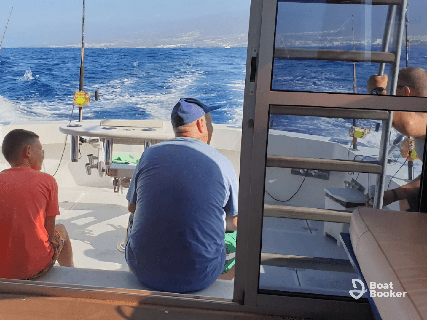 A family enjoys a fishing trip on a boat, with a scenic ocean backdrop and fishing gear ready for action.
