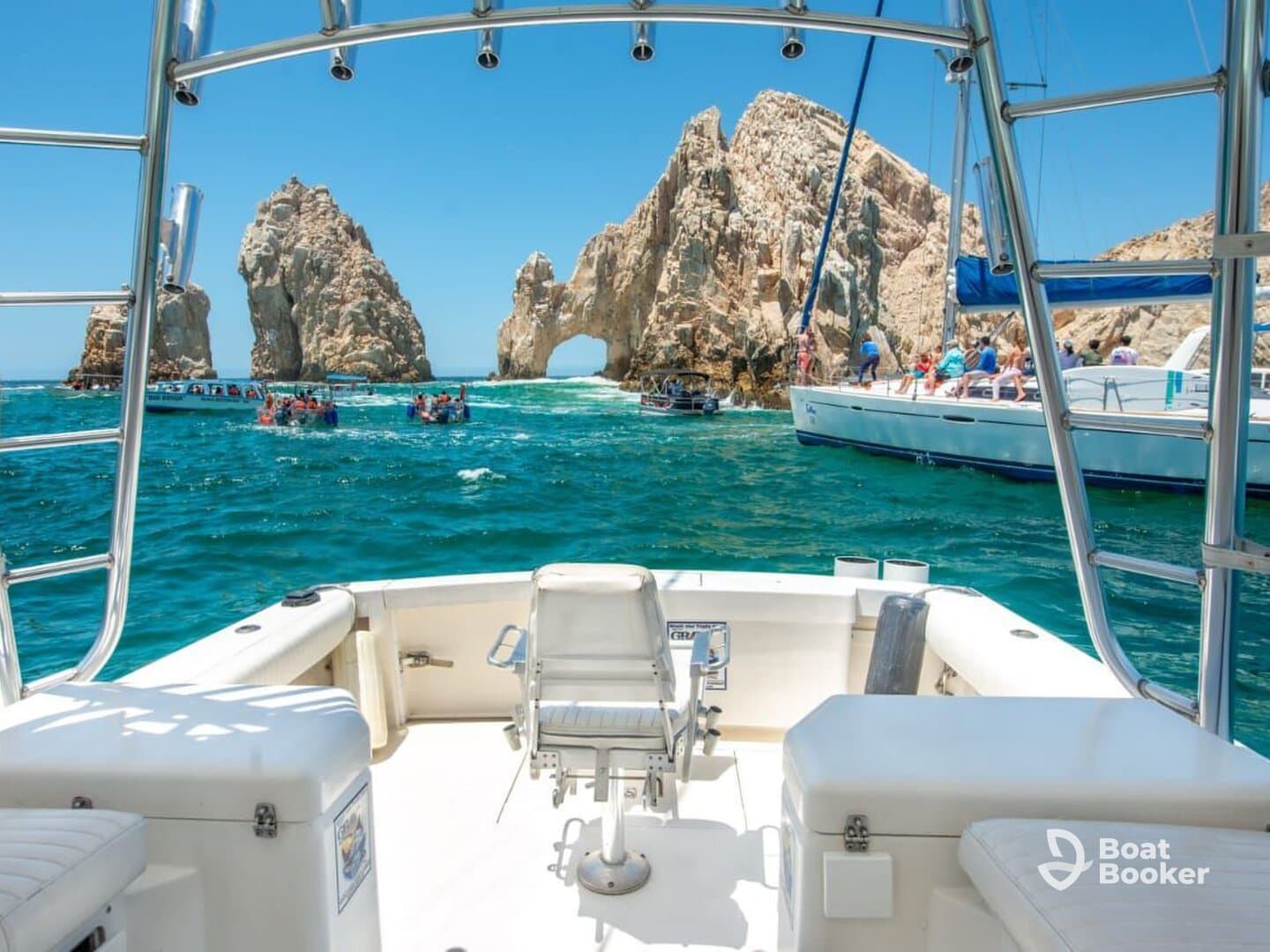 A stunning view from the deck of a boat at Cabo San Lucas, showcasing the iconic rock formations with groups of tourists enjoying the vibrant waters — a perfect destination for sightseeing and adventure.