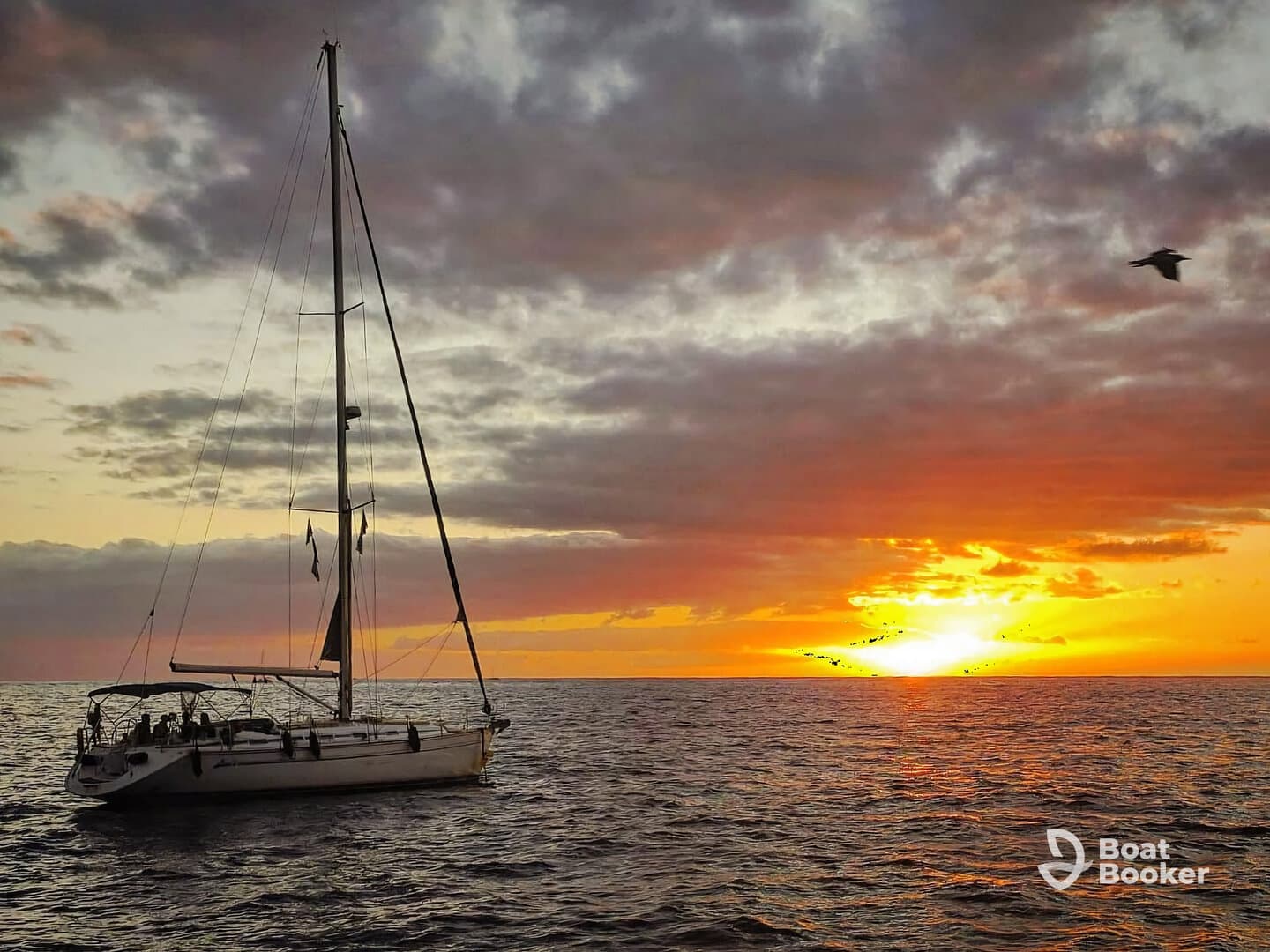 A stunning sunset view of a sailboat gliding through calm waters, perfect for serene evening cruises.