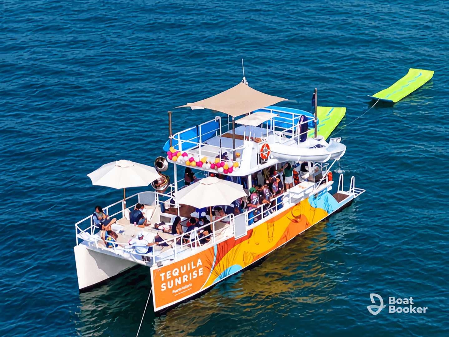 A vibrant party scene aboard the 'Tequila Sunrise' boat, filled with guests enjoying the sun and water activities — perfect for celebrations and group outings.