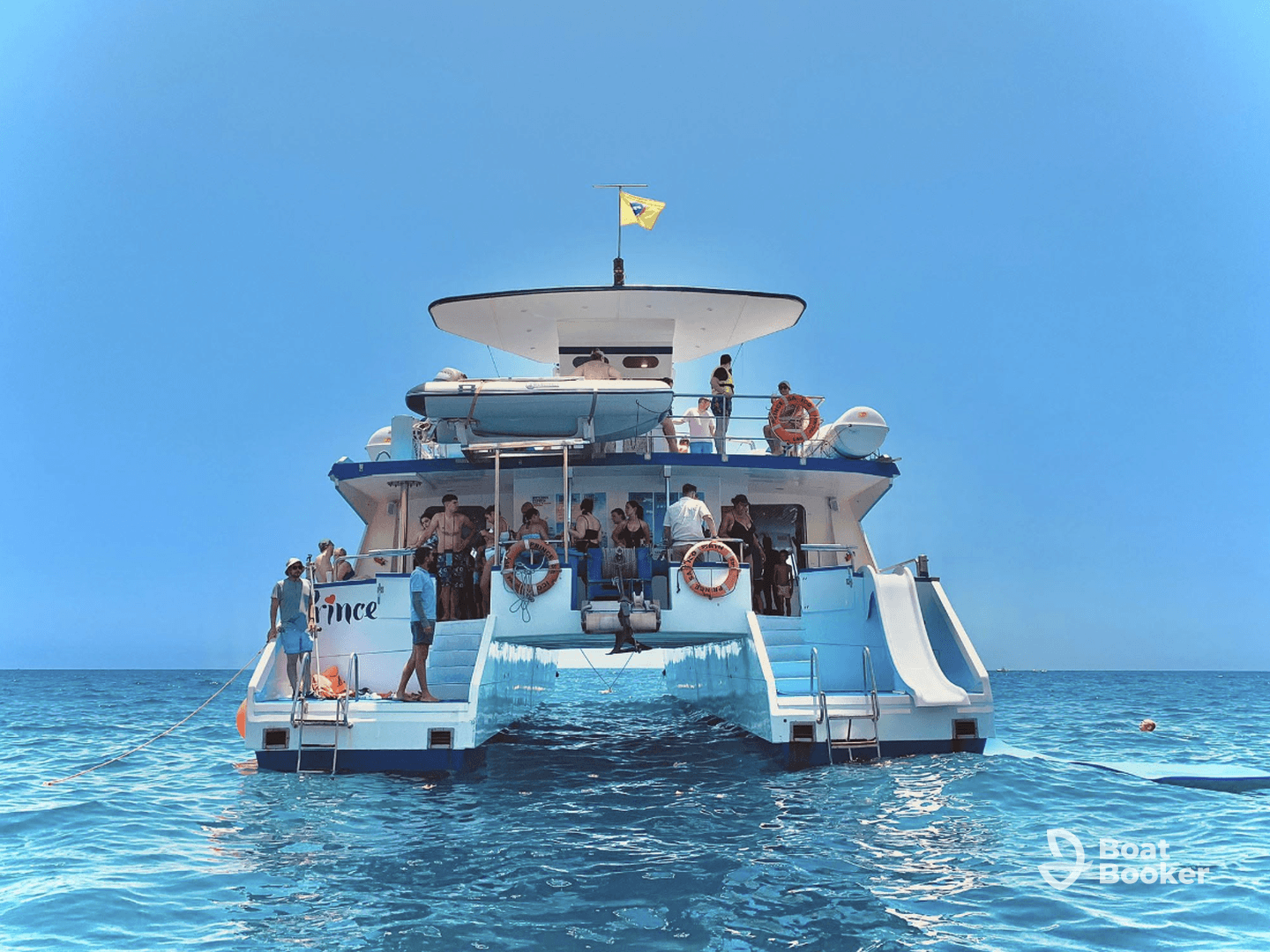 A lively group enjoys a day on a catamaran, with activities and fun in the sun — perfect for summer outings and celebrations on the water.