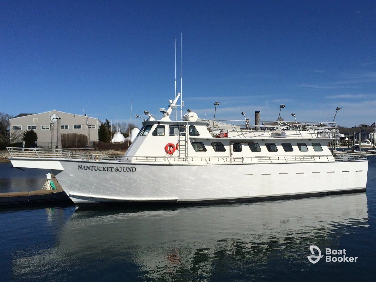 A pristine view of the 'Nantucket Sound' yacht docked at the marina, showcasing its sleek design against a clear blue sky.