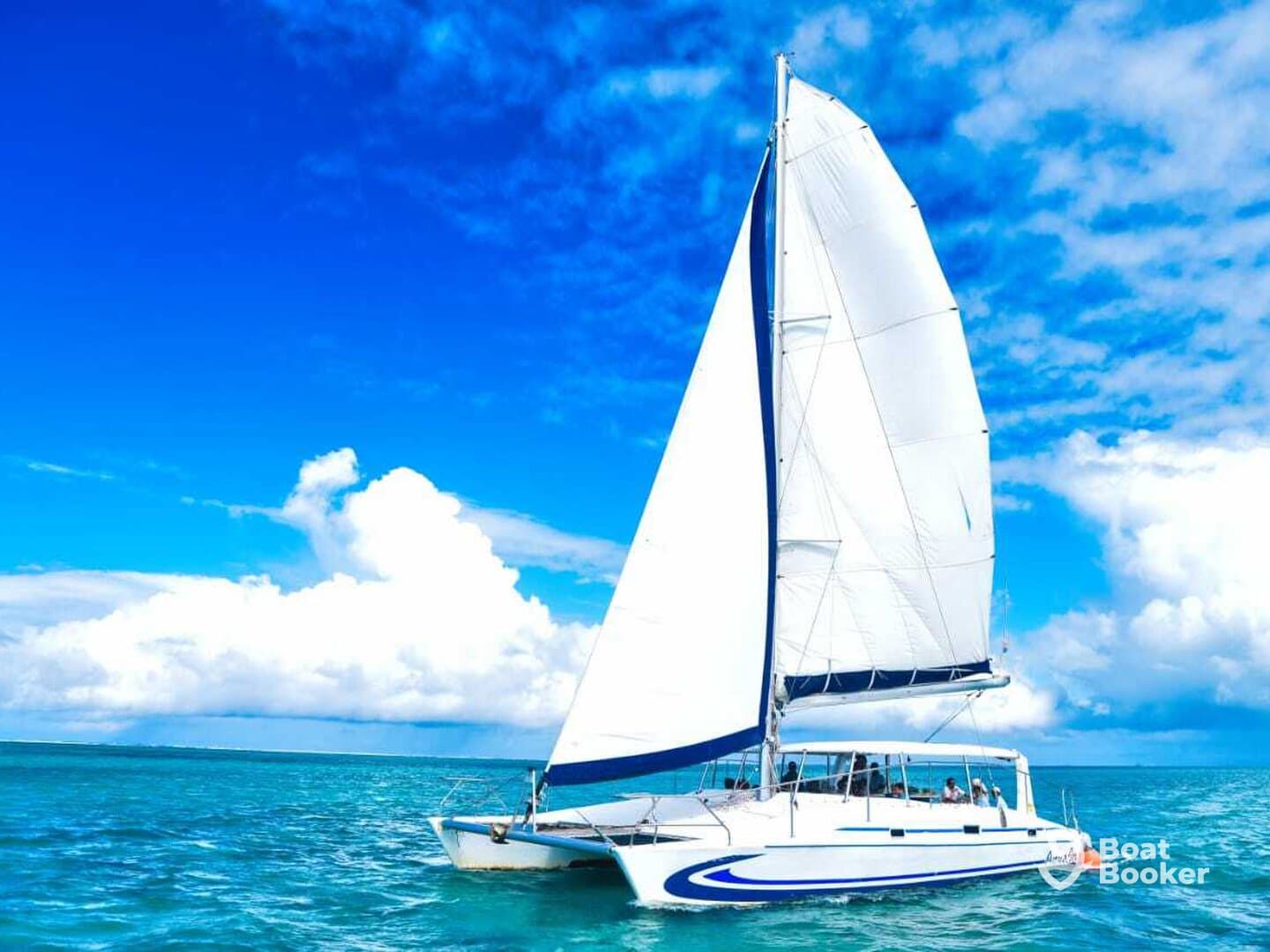 A stunning catamaran sails through vibrant turquoise waters under a bright blue sky, showcasing the perfect setting for a day on the water.