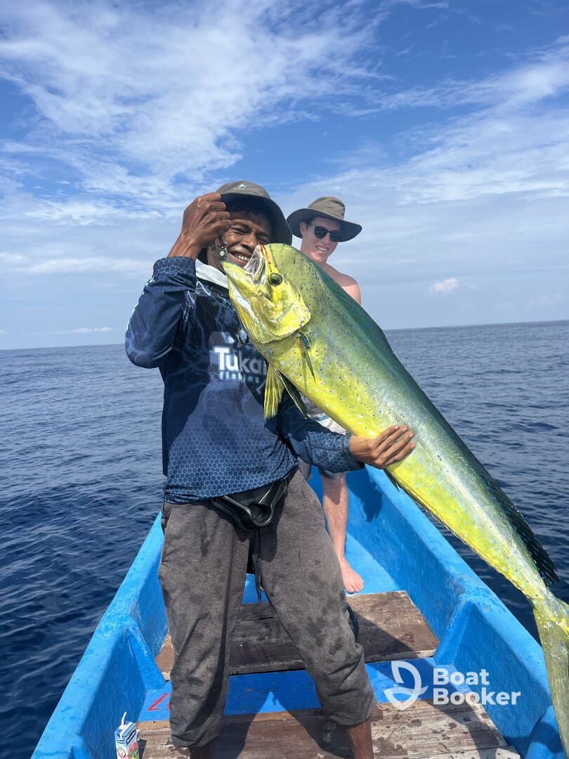 A fisherman proudly displays his impressive catch while enjoying a day on the ocean — a perfect moment for fishing enthusiasts.