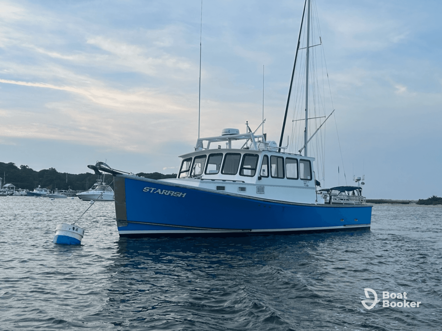 A beautiful view of the 'Starfish' boat docked in calm waters, showcasing its vibrant blue hull against a serene backdrop.