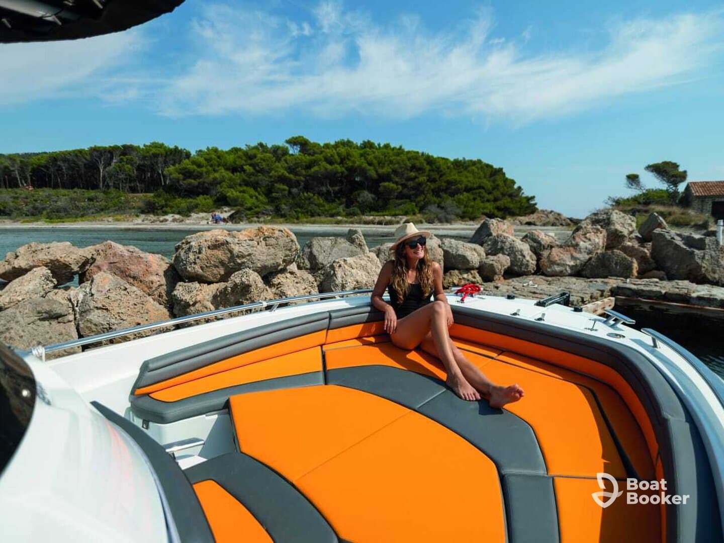 A woman relaxes on the deck of a boat, enjoying the sunny weather and beautiful scenery — perfect for a day of leisure on the water.