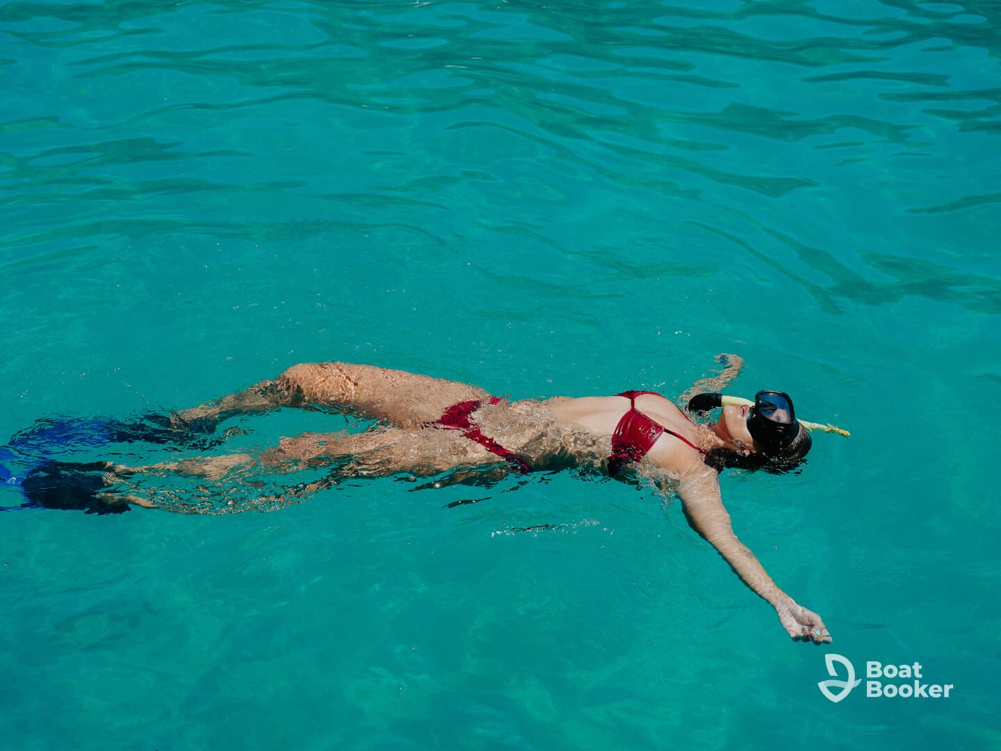 A woman enjoys snorkeling in crystal-clear waters, showcasing the beauty of underwater adventures and the joy of swimming in tropical destinations.