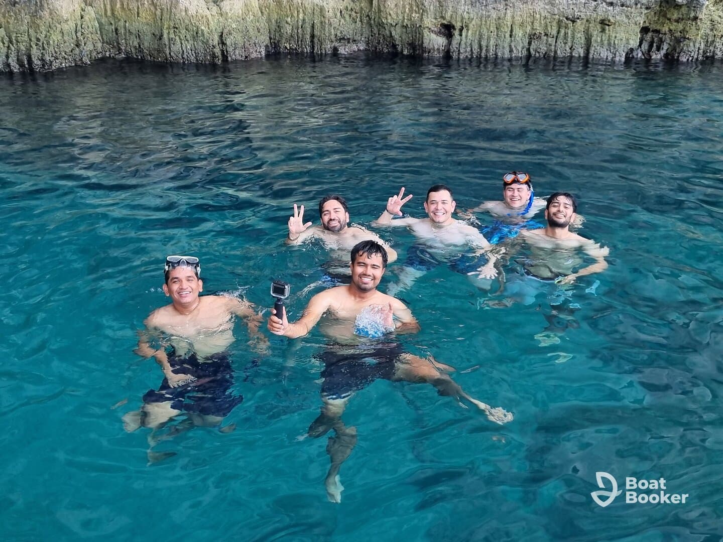 A group of friends enjoys a fun snorkeling adventure in crystal-clear waters, capturing memories while swimming in a stunning natural setting.