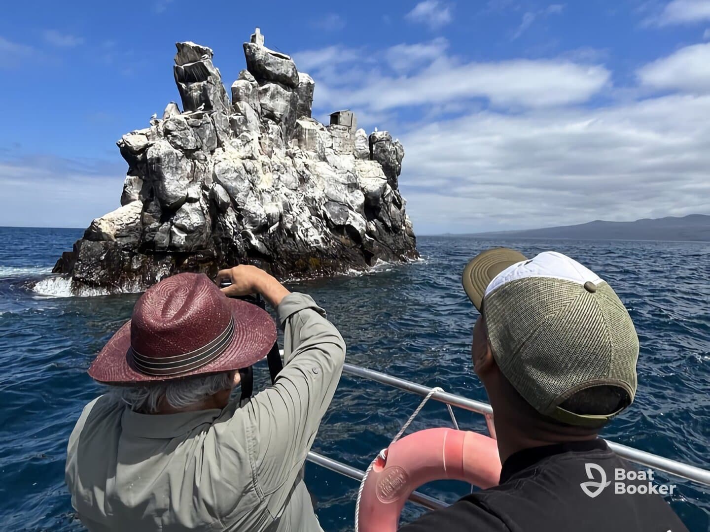 Two individuals capture the stunning rock formation while enjoying a boat trip on the ocean, showcasing the beauty of nature and adventure.
