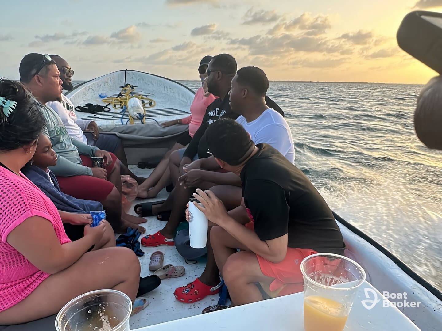 A lively group enjoys a sunset boat ride, sharing drinks and laughter, creating unforgettable memories on the water.