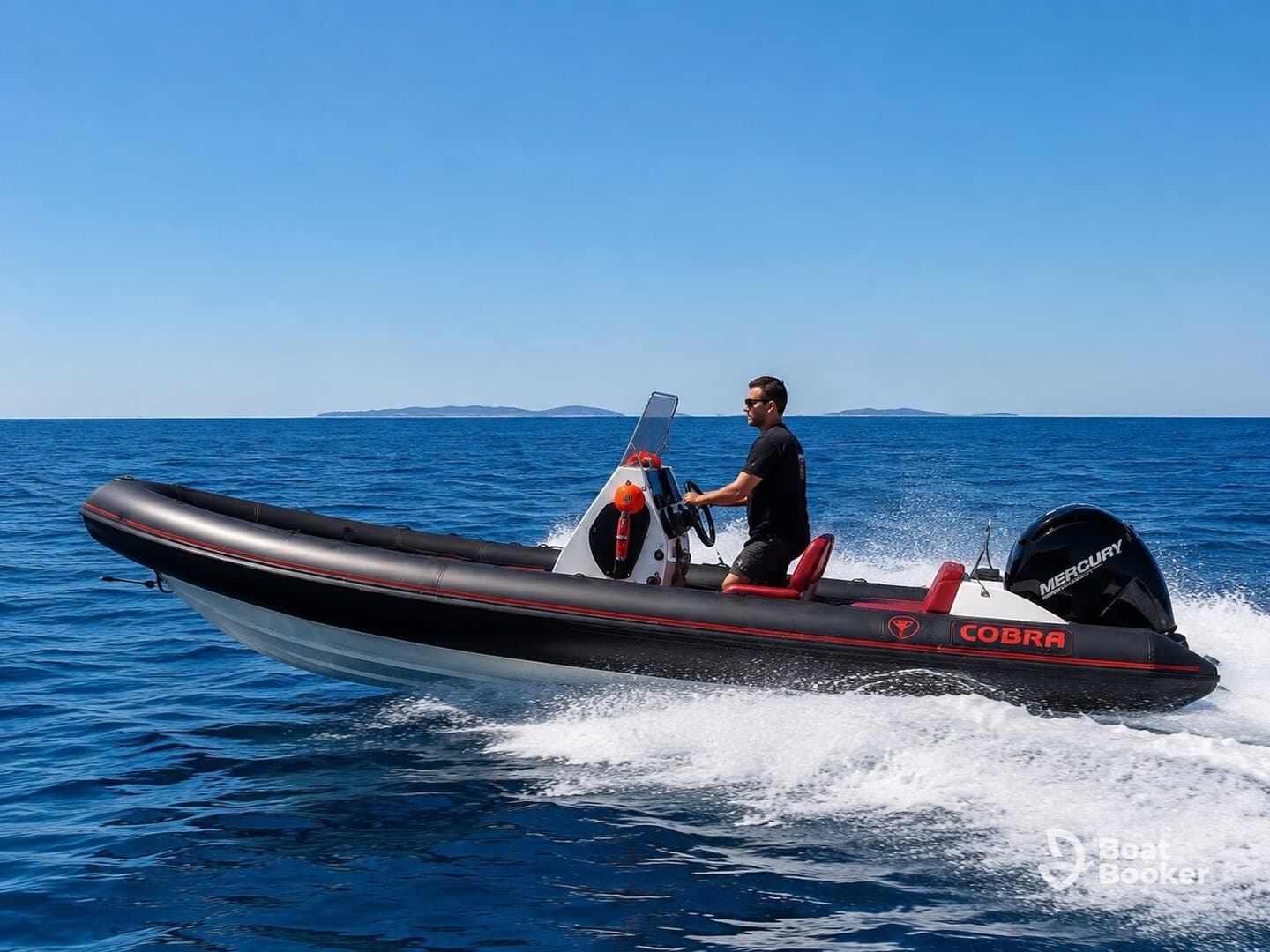 A man navigates a sleek speedboat across the open water, showcasing the thrill of boating adventures on a clear day.