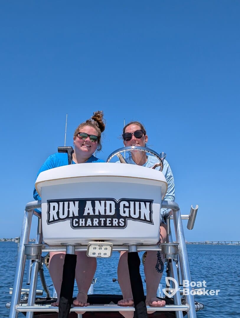 Two friends enjoy a sunny day on the water aboard a charter boat, capturing the joy of their boating adventure.