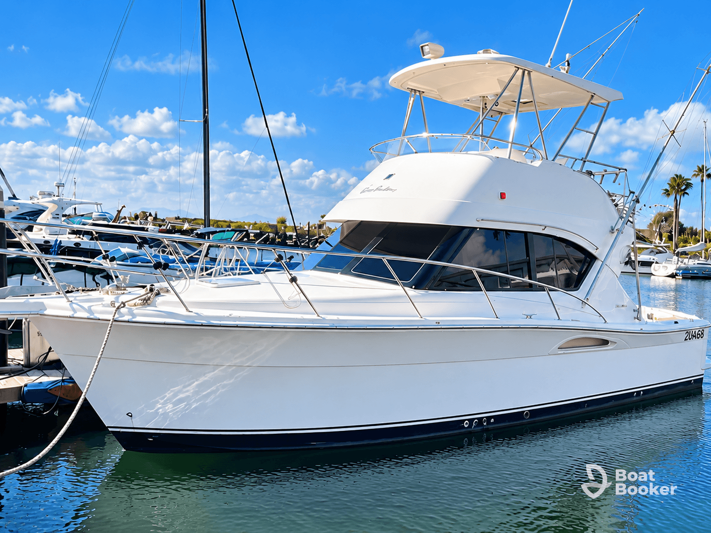 A sleek yacht docked at the marina, showcasing its elegant design against a backdrop of clear blue skies and calm waters.