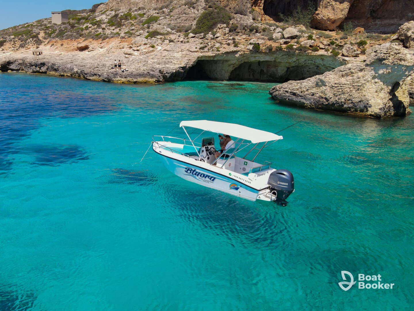 A sleek speedboat navigates through crystal-clear turquoise waters, showcasing the stunning coastal scenery — perfect for exploring hidden coves and enjoying a day on the water.