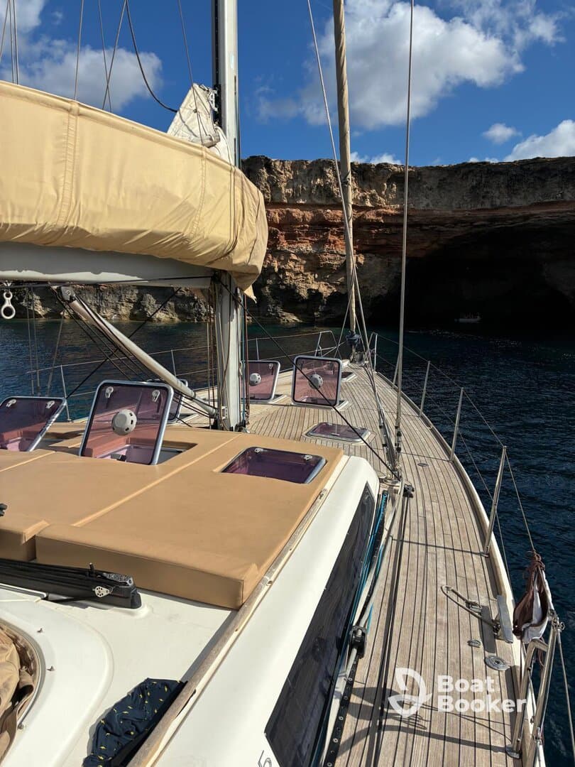 A beautiful view of a sailboat's deck, showcasing its sleek design against a stunning rocky backdrop — perfect for sailing adventures.