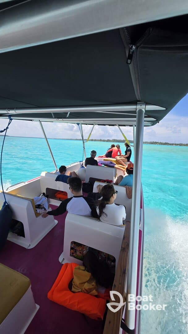 A lively group enjoys a boat ride over crystal-clear waters, perfect for creating unforgettable memories on the water.