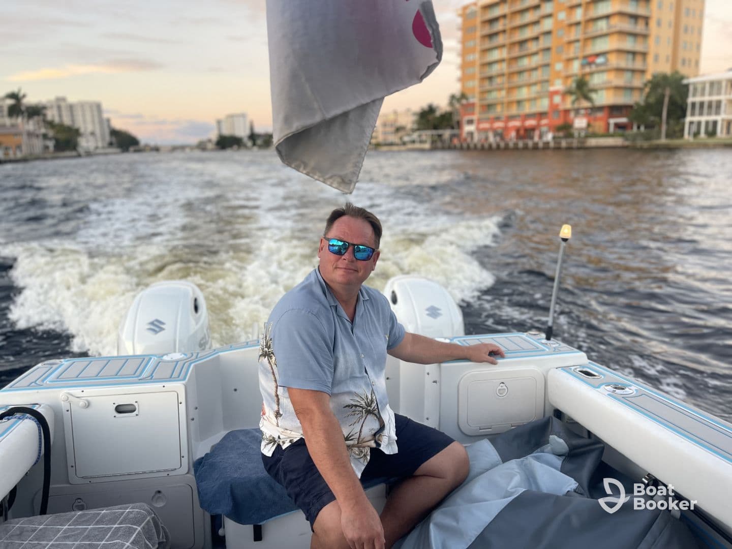 A man enjoys a leisurely cruise on a boat, showcasing the vibrant waterfront scenery — perfect for a relaxing day on the water.