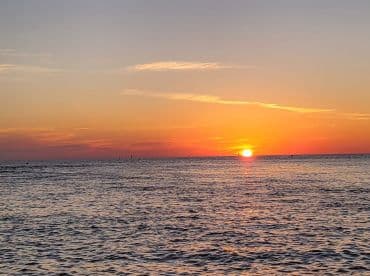 A stunning sunset over the ocean, casting vibrant colors across the sky and water — a perfect backdrop for evening boat trips and romantic getaways.
