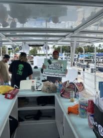 Inside view of a pontoon boat with guests preparing for a fun outing, showcasing the vibrant atmosphere and amenities available for a perfect day on the water.
