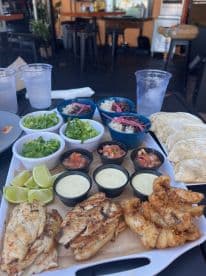 A delicious spread of grilled fish, tacos, and fresh sides, perfect for enjoying a meal on board or at a waterfront restaurant.