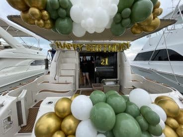 A festive setup for a 21st birthday celebration aboard a boat, adorned with balloons and decorations, creating a perfect atmosphere for memorable moments on the water.