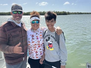 A joyful family poses for a photo on a fishing trip, showcasing the fun and adventure of spending time together on the water.