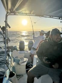 A group of friends enjoys a fishing trip at sunset, casting lines into the shimmering ocean — a perfect blend of adventure and relaxation on the water.