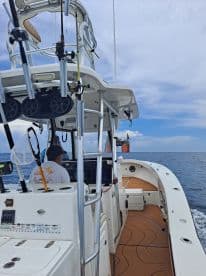 Inside view of a fishing boat's helm, showcasing the console and gear, perfect for deep-sea fishing adventures.