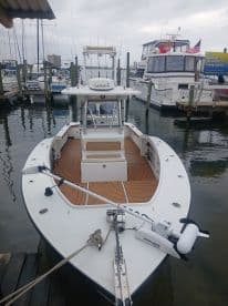 A clear view of a fishing boat docked at the marina, showcasing its sleek design and equipped with modern fishing gear — perfect for anglers looking for a day on the water.