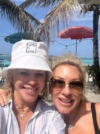 Two friends enjoy a sunny day at the beach, celebrating friendship with smiles and laughter — perfect for memorable vacation moments.