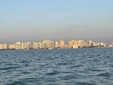 A scenic view of a vibrant city skyline along the coastline, captured from the water — perfect for showcasing urban beauty from a unique perspective.
